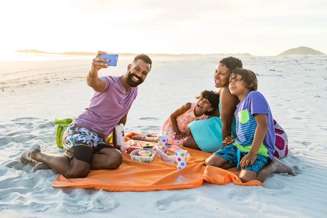 Happy family enjoying a beach picnic and selfie during UAE holidays 2026