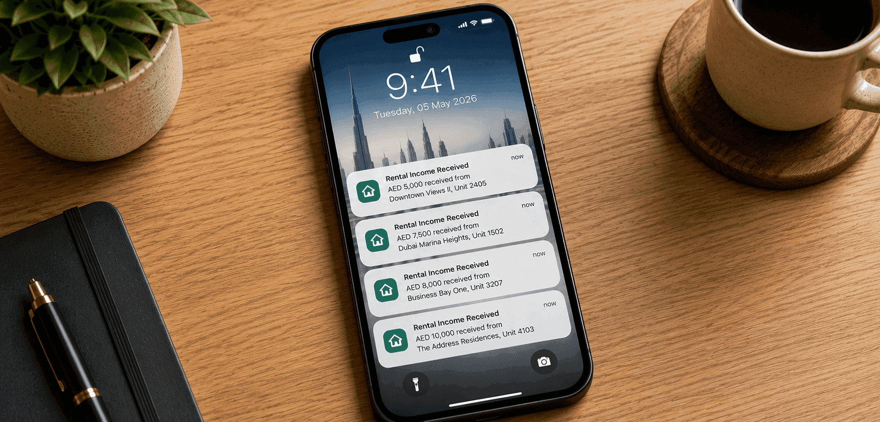 Smartphone on a wooden desk displaying multiple rental income notifications from Dubai investment