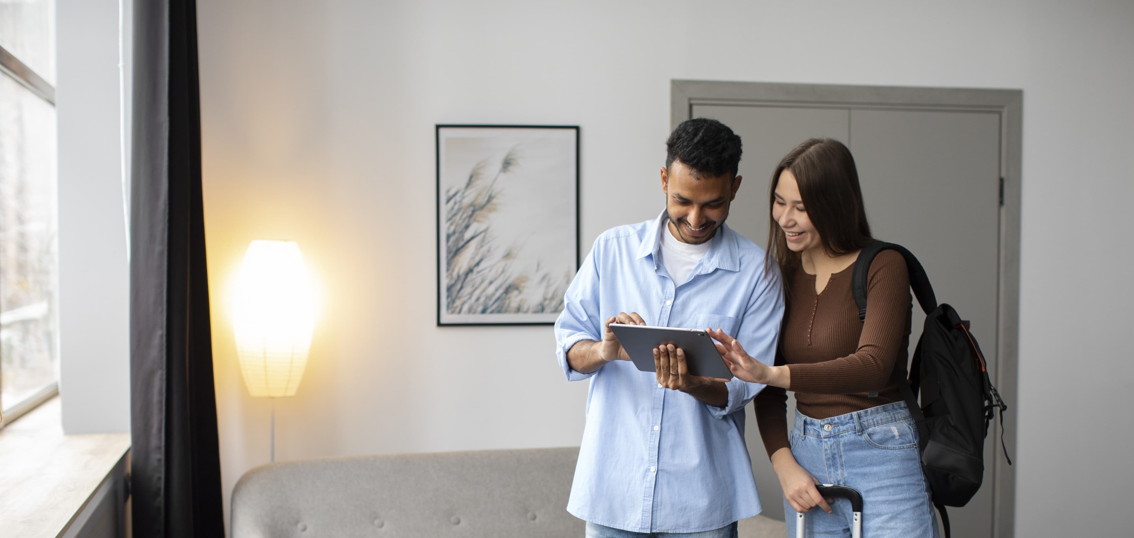 Couple reviewing rental property details on a tablet in Dubai apartment